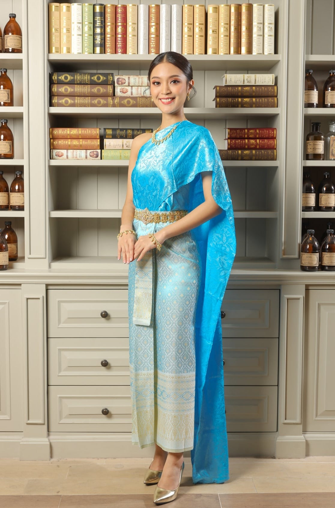A woman posing in a sky blue traditional Thai dress.