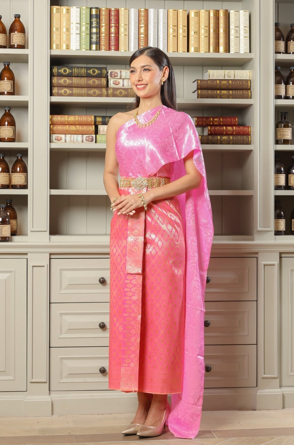 A woman wearing a flirty pink traditional Thai dress.