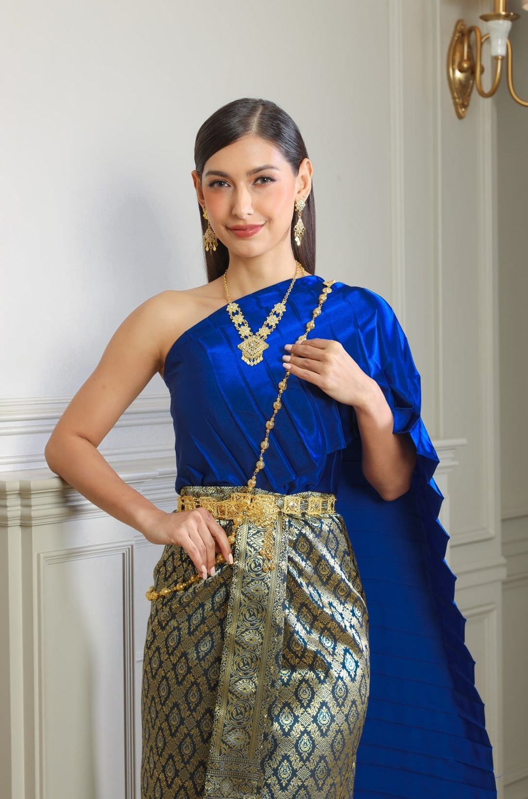 A woman posing in a traditional Thai dress.