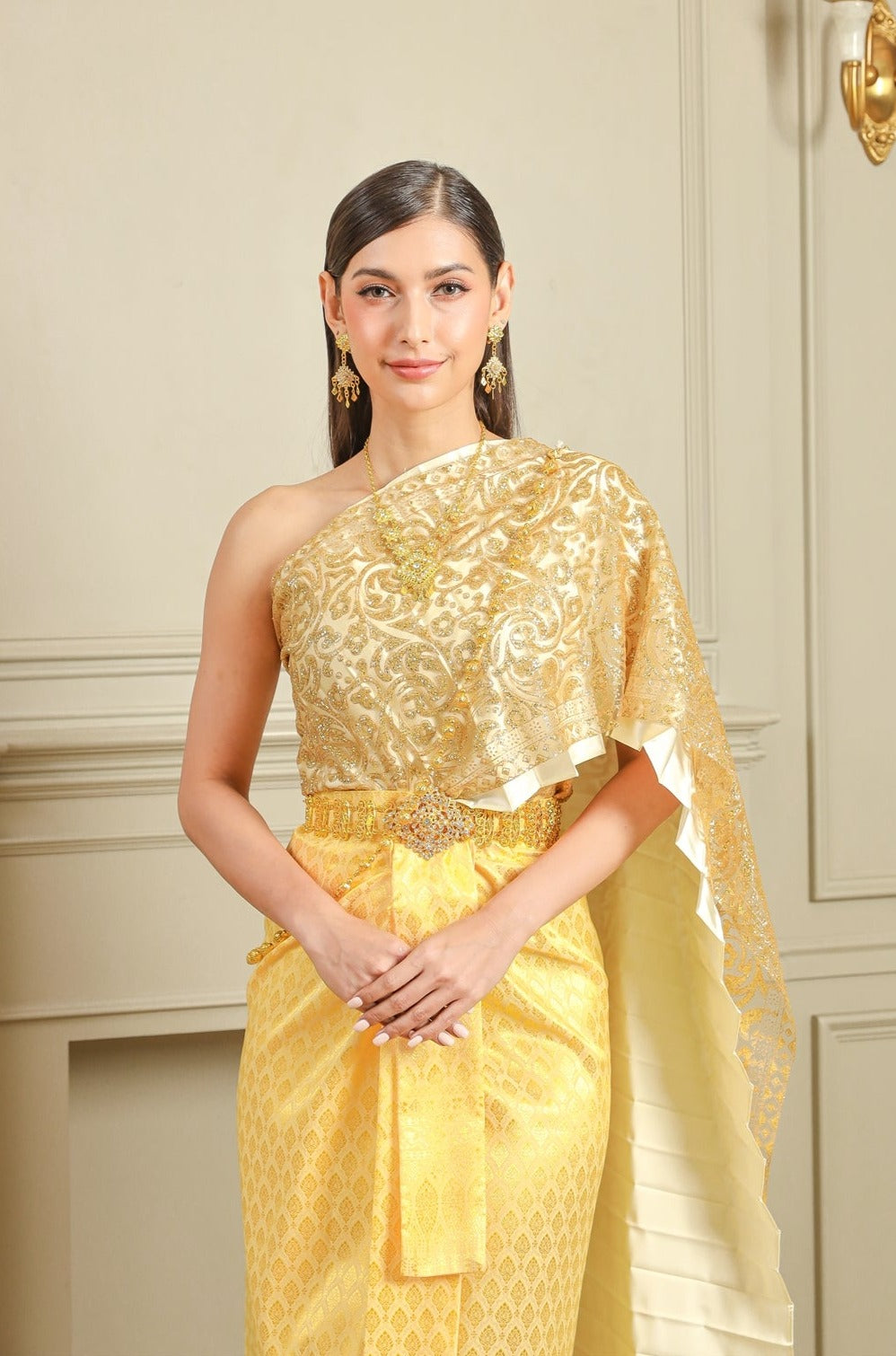 A woman wearing our gold traditional Thai dress.
