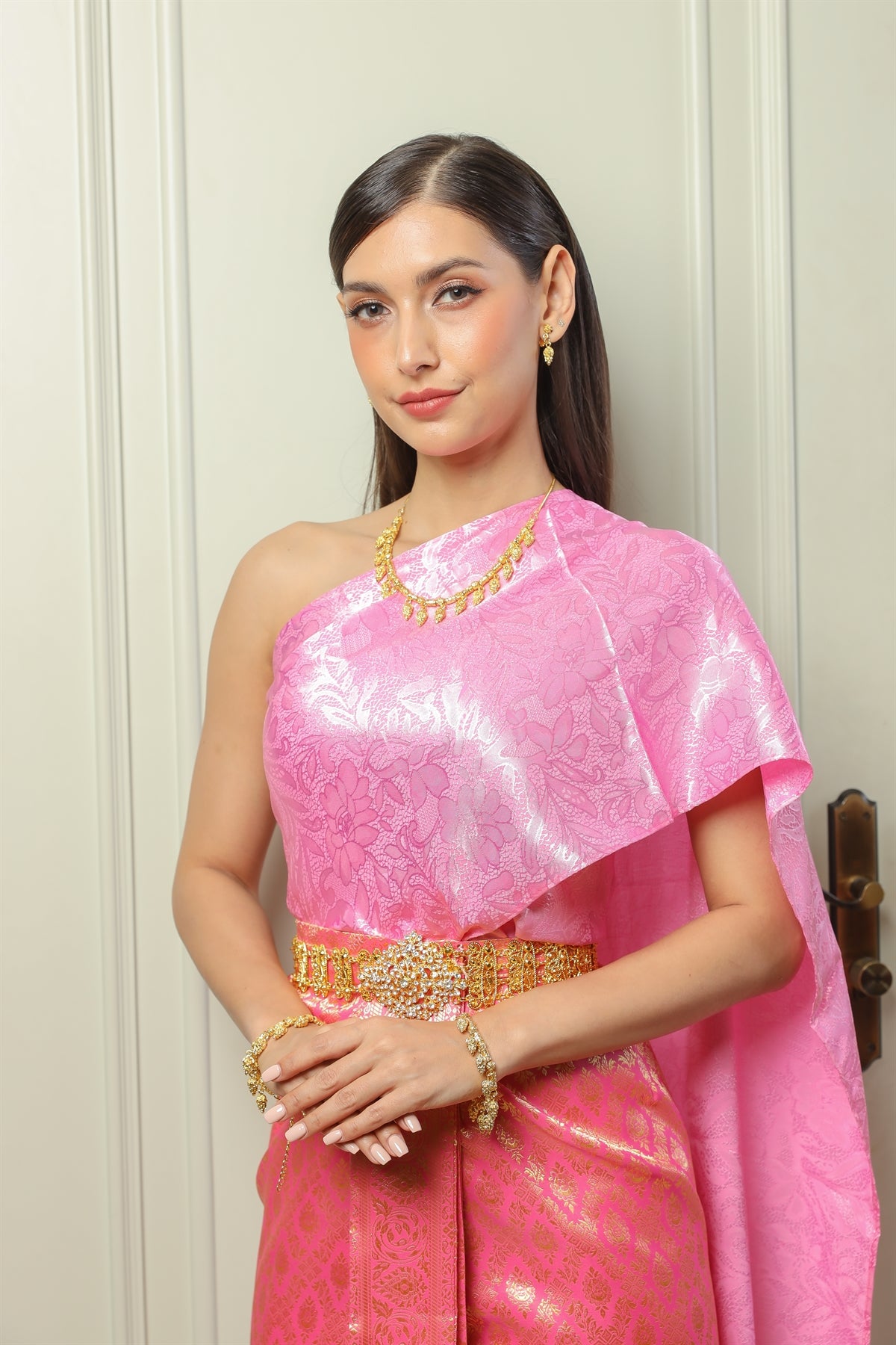 A woman posing in her traditional Thai dress and jewelry.
