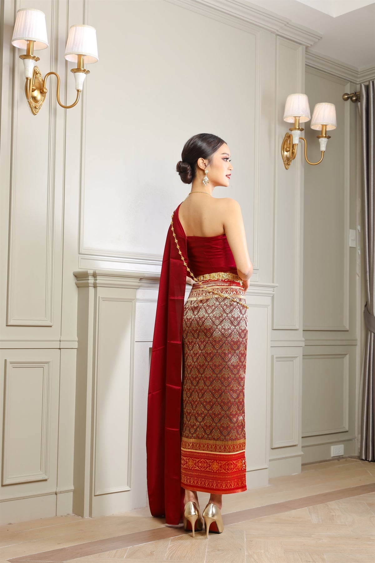 A Thai woman posing in her traditional Thai dress and jewelry.