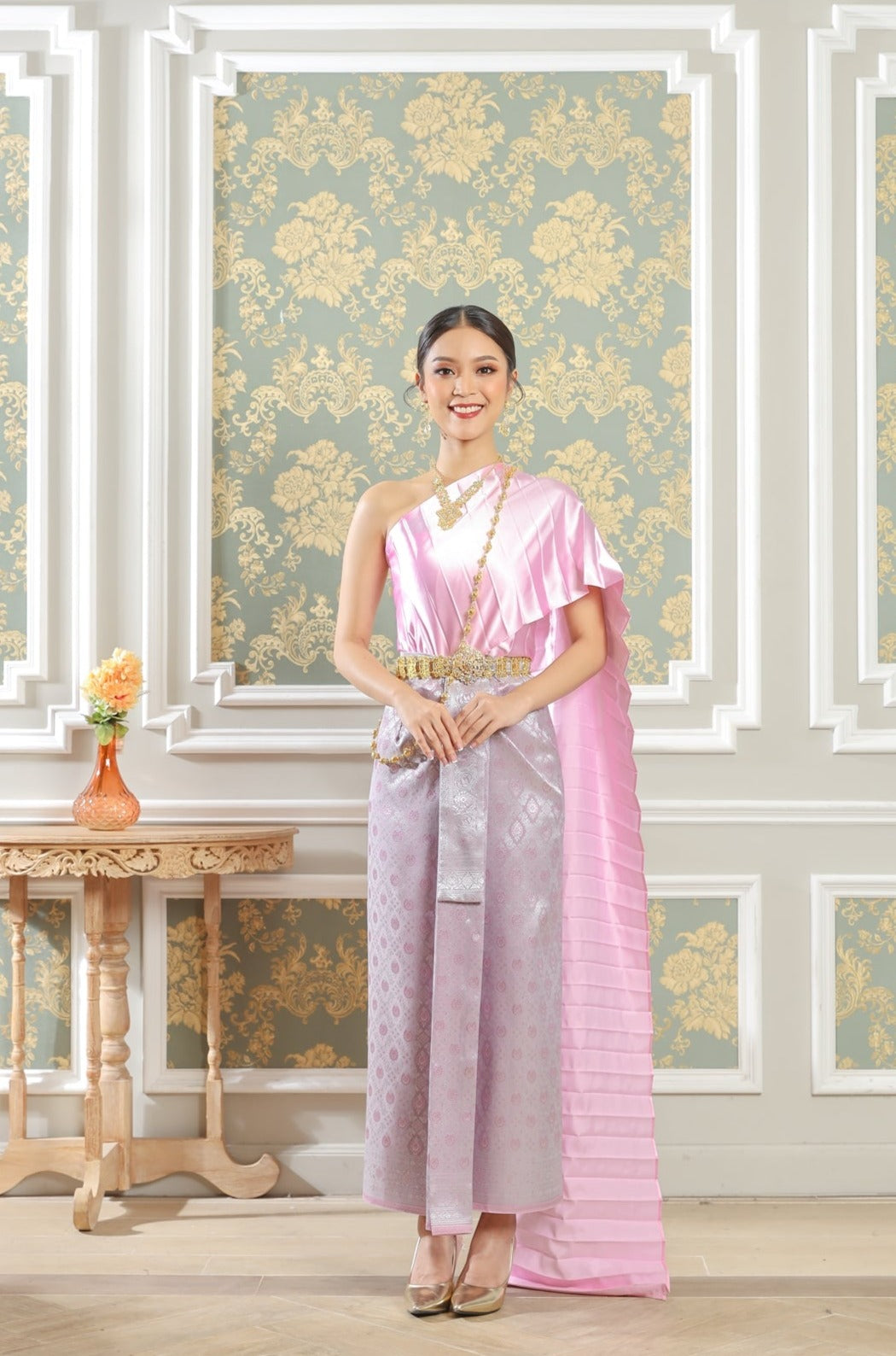 A woman wearing a pink Thai traditional dress.