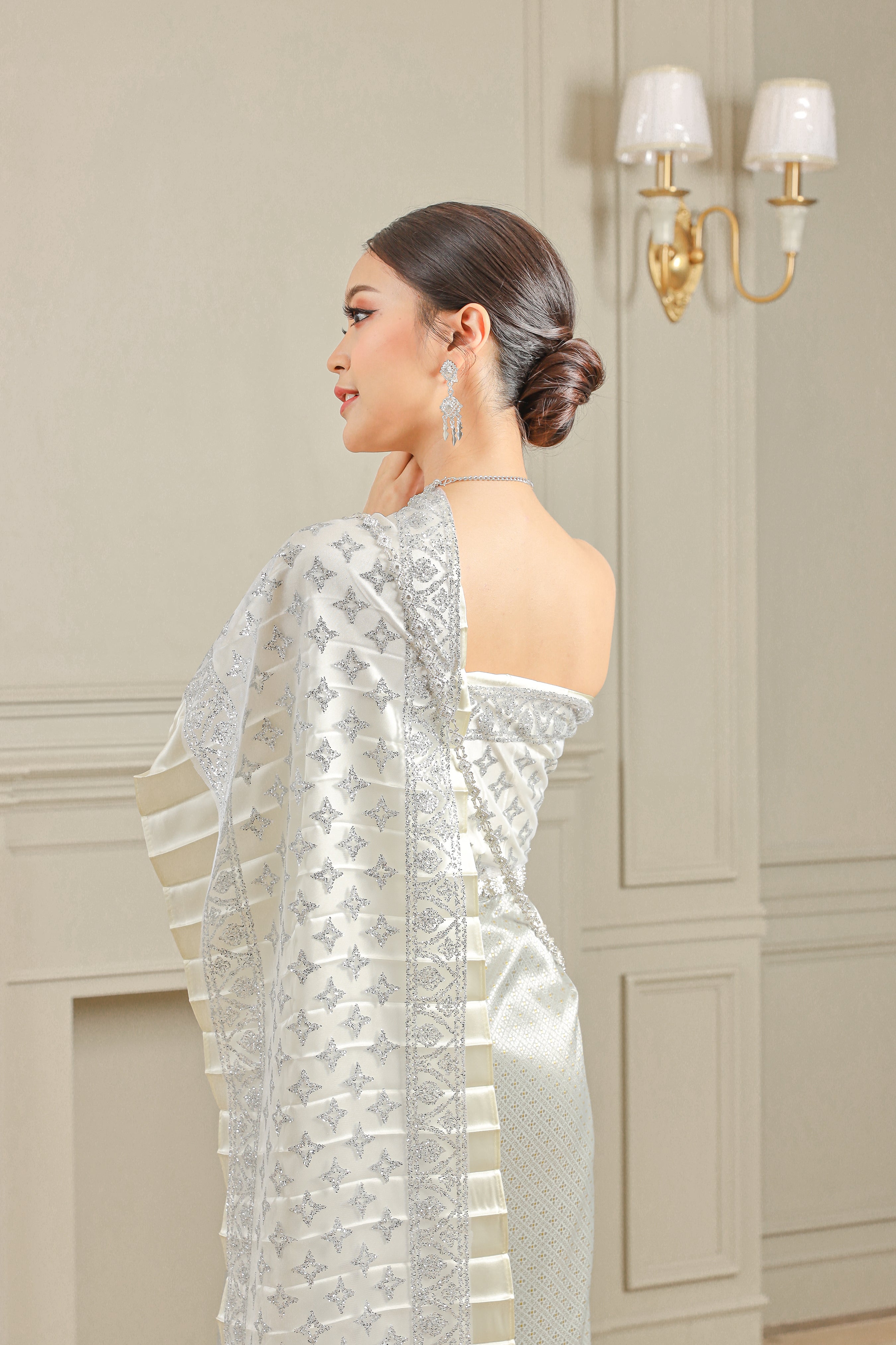 Image of a woman dressed in a silver Thai dress