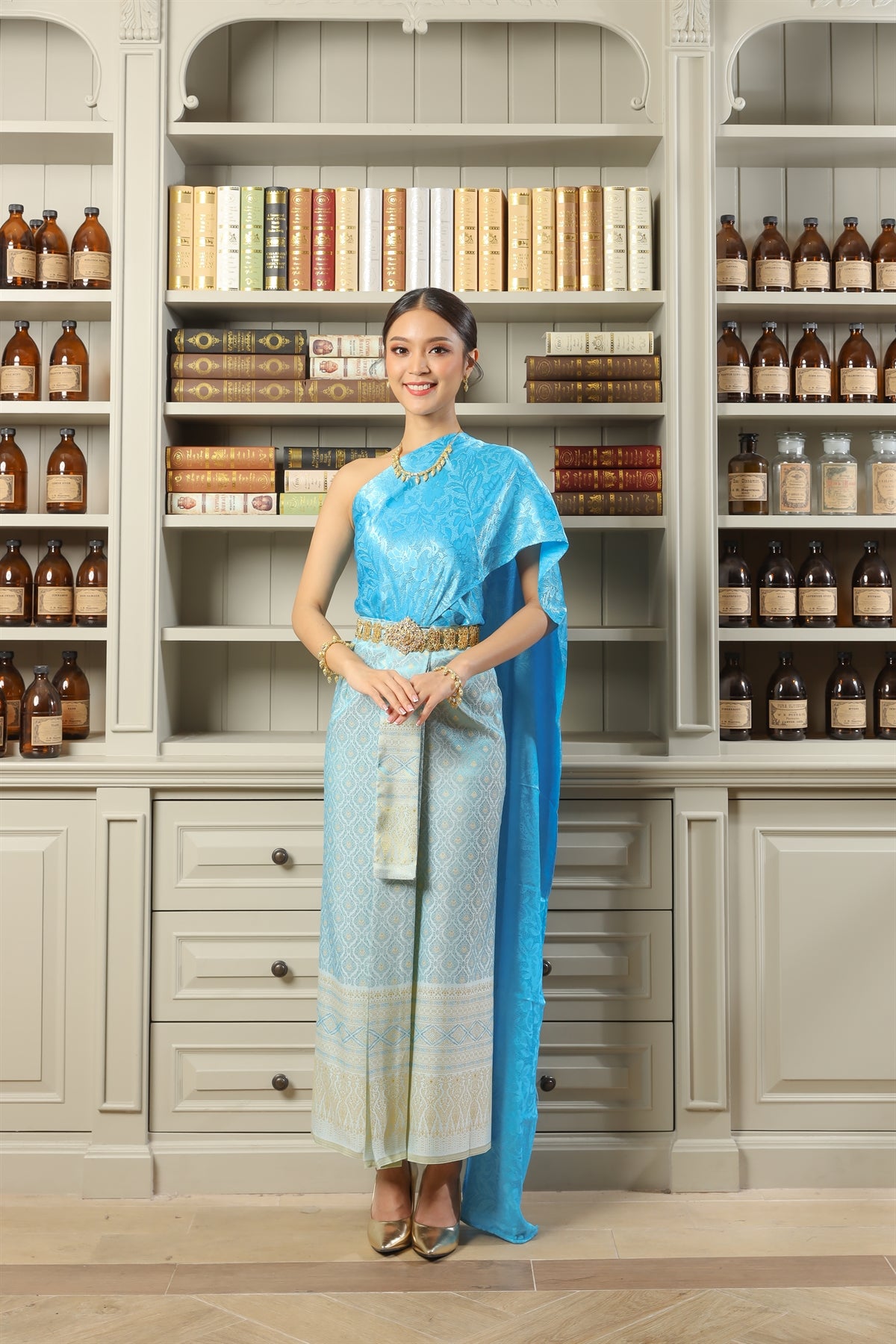 A woman smiles while wearing her traditional Thai dress.